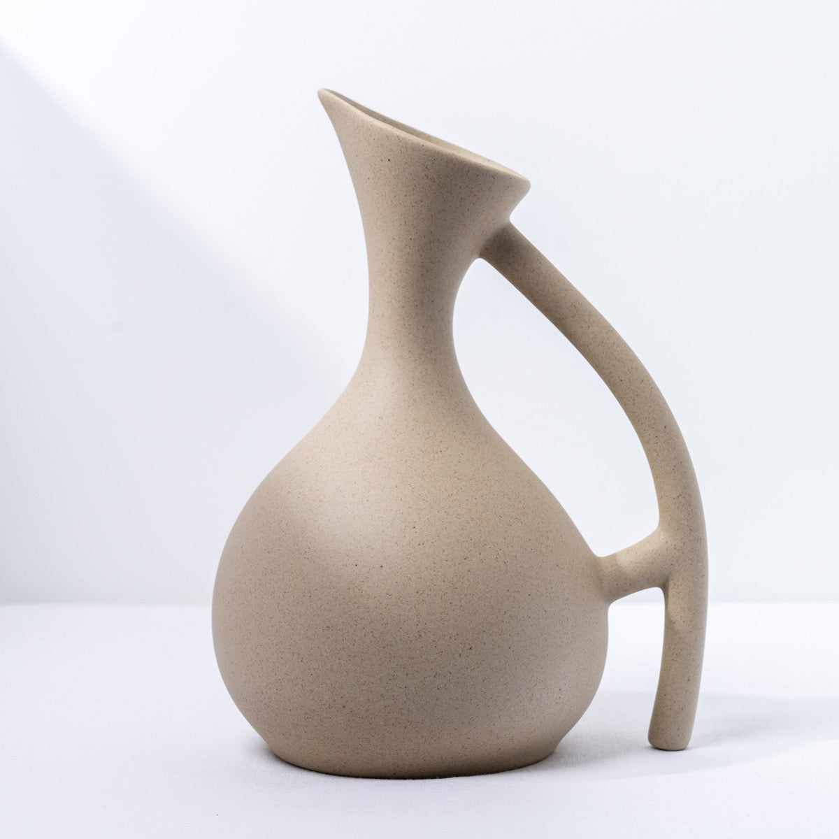 Sleek ceramic pitcher with a smooth finish, perfect for adding a touch of elegance to any table setting.